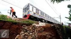 Pekerja meletakkan batuan untuk memperkuat struktur tanah yang longsor dekat rel KRL di sekitar Kampung Pabuaran, Bogor, Rabu (25/11/2015). Sebelumnya, Selasa (24/11) tanah di sekitar rel KM 38 dan 39 mengalami longsor. (Liputan6.com/Helmi Fithriansyah)