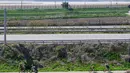 Dalam foto yang diambil pada tanggal 24 April 2025 ini memperlihatkan para pesepeda (bawah) terlihat dari halaman kafe Daonsoop, yang dibangun kurang dari dua kilometer dari perbatasan Korea Utara (latar belakang) di Paju, sebelah utara Seoul, Korea Selatan. (ANTHONY WALLACE/AFP)