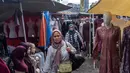 Langkah dinilai banyak pihak menjadi titik balik bagi kebangkitan industri tekstil nasional. Tampak dalam foto, pembeli berjalan di antara kios-kios penjual pakaian lokal di salah satu pasar tradisional, Jakarta, Kamis 20 November 2025. (BAY ISMOYO/AFP)