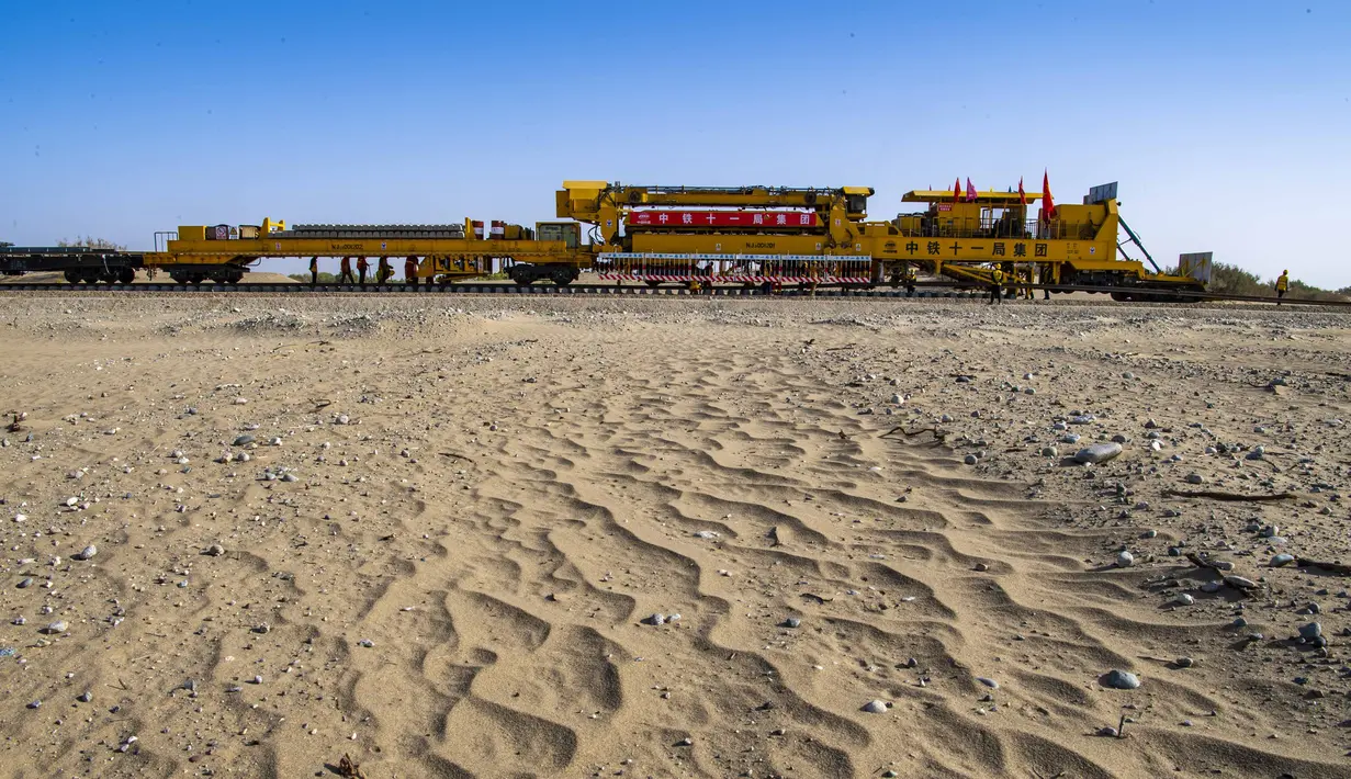 Sebuah mesin menempatkan rel di lokasi konstruksi jaringan kereta Hotan-Ruoqiang di Daerah Otonom Uighur Xinjiang, China, 25 September 2020. Dengan total panjang sekitar 825 kilometer, jaringan kereta itu merupakan bagian penting dari loop kereta di Lembah Tarim. (Xinhua/Hu Huhu)