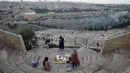 Warga Palestina berkumpul untuk berbuka puasa selama bulan suci Ramadan dengan latar belakang Kota Tua Yerusalem dan kompleks Masjid al-Aqsa yang ditutup selama krisis pandemi coronavirus di Bukit Zaitun (19/5/2020). (AFP/Ahmad Gharabli)