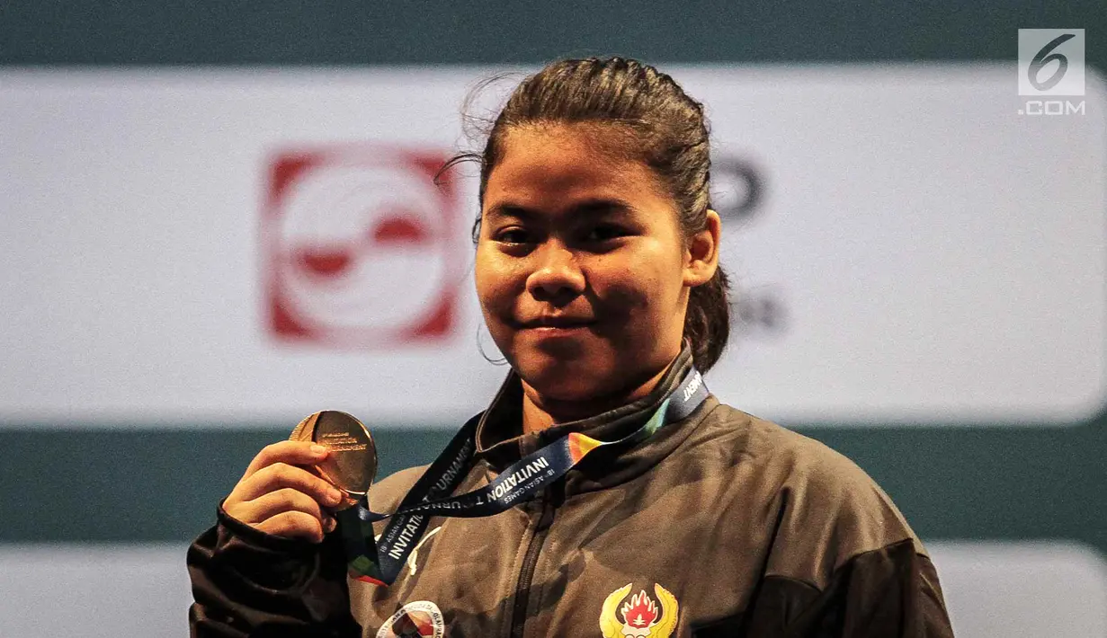 Senyum bahagia lifter Indonesia Melinda Gusti usai memperoleh emas pada nomor angkat besi putri 75 Kg 18th Asian Games Invitation Tournament di JiExpo, Jakarta, Senin (12/2). (Liputan6.com/Faizal Fanani)