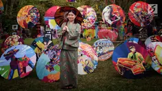 Pengunjung berfoto di sekitar dekorasi payung pada acara Festival Payung Indonesia 2018 di Taman Lumbini, Komplek Candi Borobudur, Magelang, Jumat (7/9). Acara tahunan kali ini bertema 'Sepayung Indonesia, Lalitavistara'. (Liputan6.com/Gholib)