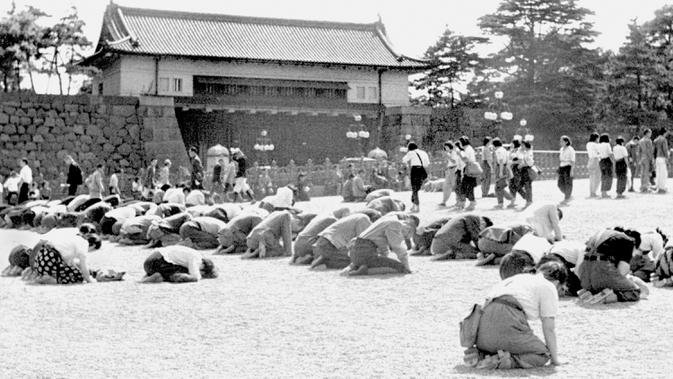 Warga berlutut saat Kaisar Hirohito mengumumkan lewat radio bahwa Jepang telah dikalahkan dalam Perang Dunia II di depan Istana Kekaisaran, Tokyo, Jepang, 15 Agustus 1945. Tanggal 2 September 2020 menjadi peringatan 75 tahun penyerahan resmi Jepang kepada Amerika Serikat.  (Kyodo New via AP, File)