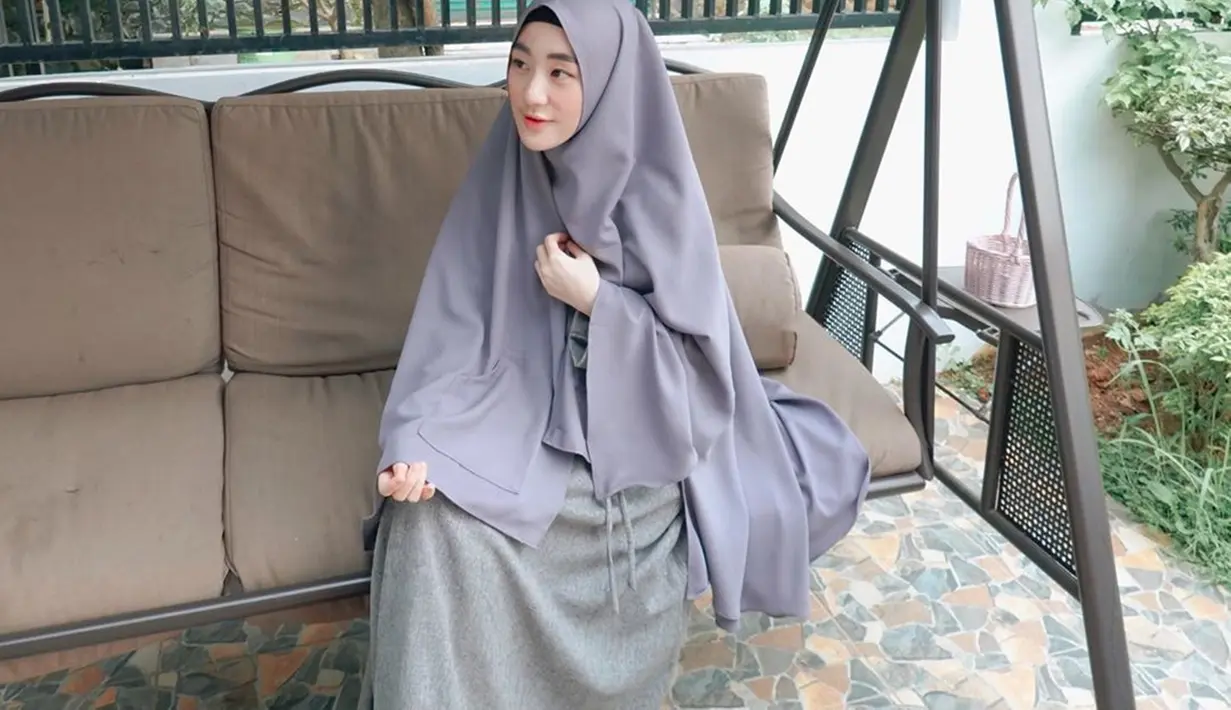 Menggunakan hijab syar'i bewarna abu serta gamis yang senada membuat pesona ibu satu anak ini kecantikannya semakin terpancar. (Liputan6.com/IG/larissachou)