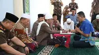 Kepala BPBD Sampang, Anang Djoenaidi saat prosesi mengucap dua kalimat syahadat dibimbing langsung Rois Syuriah PCNU Sampang KH Syafiuddin Abdul Wahid. (liputan6.com/Musthofa Aldo)