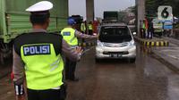 Petugas memberhentikan sebuah mobil saat penyekatan larangan mudik lebaran di gerbang tol Cikupa, Kabupaten Tangerang, Banten, Kamis (6/5/2021). Penyekatan dilakukan seiring telah diberlakukan larangan mudik Lebaran mulai dari 6 hingga 17 Mei 2021.  (Liputan6.com/Angga Yuniar)