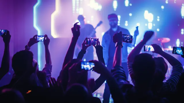 Ilustrasi nonton konser dan mengabadikan momen pakai smartphone