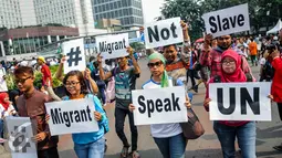 Massa yang tergabung dalam Jaringan Buruh Migran Indonesia (JBMI) menggelar aksi dukungan terhadap suara migran dunia di Car Free Day, Jakarta, Minggu (18/9). (Liputan6.com/Faizal Fanani)