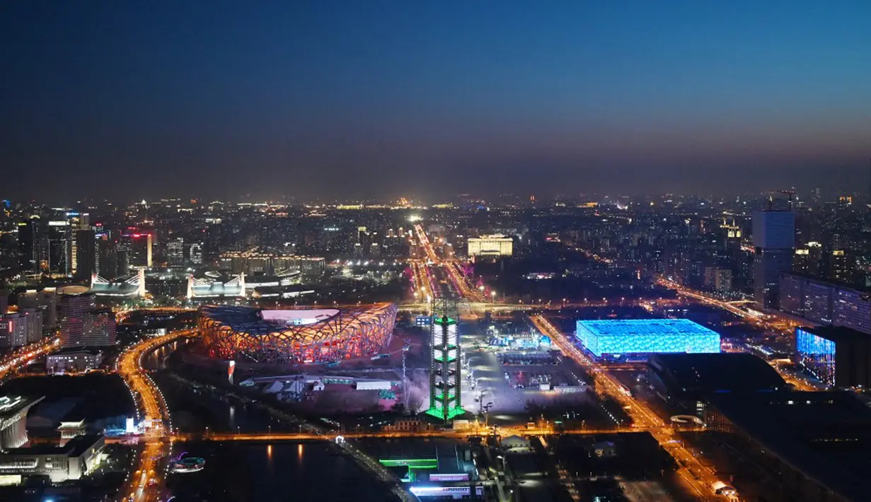 National Aquatics Center yang dikenal sebagai Ice Cube (kanan) venue untuk curling pada Olimpiade Musim Dingin 2022 dan National Stadium yang dikenal sebagai Bird's Nest (kiri) terlihat di Beijing, 3 Januari 2022. Olimpiade Musim Dingin 2022 akan dibuka pada 4 Februari mendatang. (GREG BAKER/AFP)