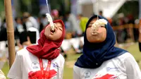 Lomba makan kerupuk memeriahkan HUT RI ke-69 di kawasan Tugu Monas, Jakarta, (31/8/2014). (Liputan6.com/Helmi Fithriansyah)
