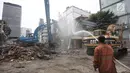 Petugas menyemprotkan air ke bangunan yang dirobohkan di kompleks Pasar Blora, Jakarta, Kamis (25/1). Lahan milik PD Pasar Jaya itu rencananya akan dibangun pasar kembali. (Liputan6.com/Arya Manggala)