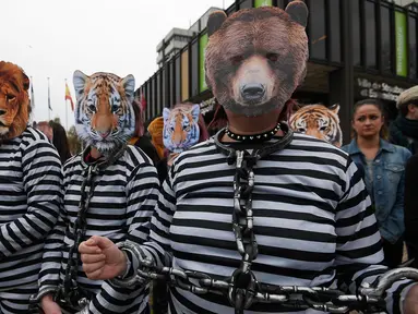 Para pemrotes mengenakan pakaian penjara dan topeng binatang saat melakukan aksinya di Strasbourg, Prancis (12/4). Mereka melakukan aksi untuk menolak penggunaan hewan dalam pertunjukan sirkus. (AFP/Frederick Florin)