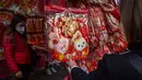 Para pembeli melihat dekorasi Tahun Baru Imlek yang dijual di sebuah kios pinggir jalan di Distrik Sham Shui Po, Hong Kong, 18 Januari 2023. Tahun Baru Imlek 2023 yang disebut Tahun Kelinci akan jatuh pada tanggal 22 Januari. (AP Photo/Anthony Kwan)
