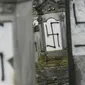 Sejumlah batu nisan dan monumen Holocaust yang dicoret-coret dengan simbol swastika nazi di sebuah pemakaman Yahudi di Strasbourg, Prancis (17/12). Aksi vandalisme ini diketahui dilakukan Selasa di pemakaman Yahudi Herrlisheim. (AFP Photo/Sebastien Bozon)