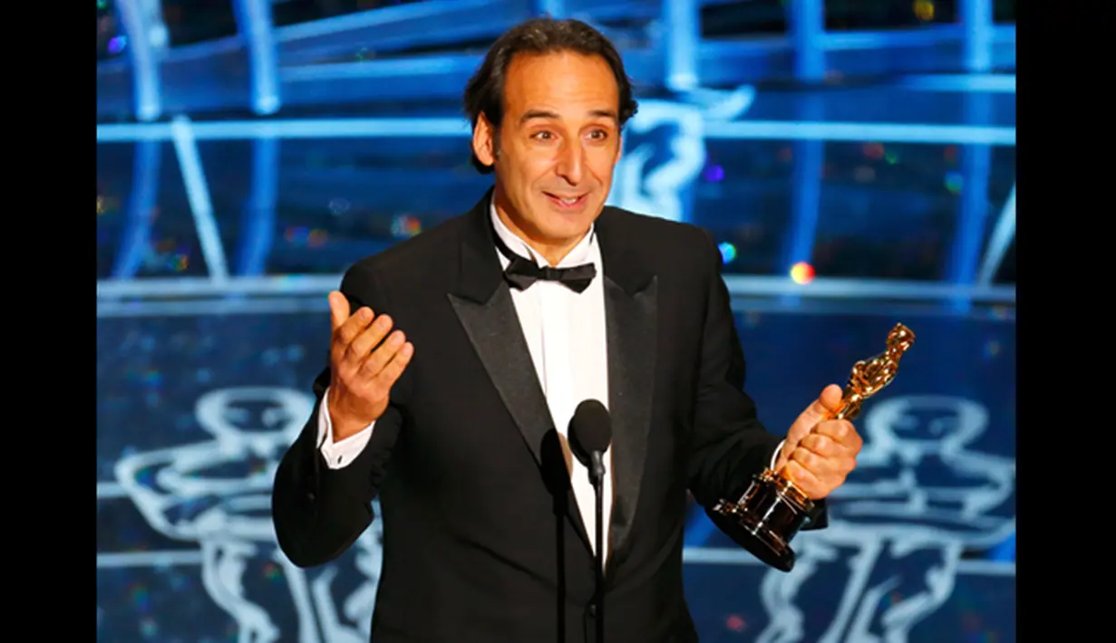 Alexandre Desplat menerima piala Oscar untuk komposer  terbaik dalam film "The Grand Budapest Hotel," menerima Oscar-nya di Academy Awards ke-87 di Dolby Theatre, Los Angeles, California, (22/2/2015). (Reuters/Mike Blake)