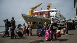 Penumpang tiba di pelabuhan di Surabaya, Jawa Timur, Kamis (28/4/2022). Orang-orang melakukan perjalanan ke kota asalnya menjelang Idul Fitri yang menandai berakhirnya bulan suci Ramadhan. (Juni Kriswanto/AFP)