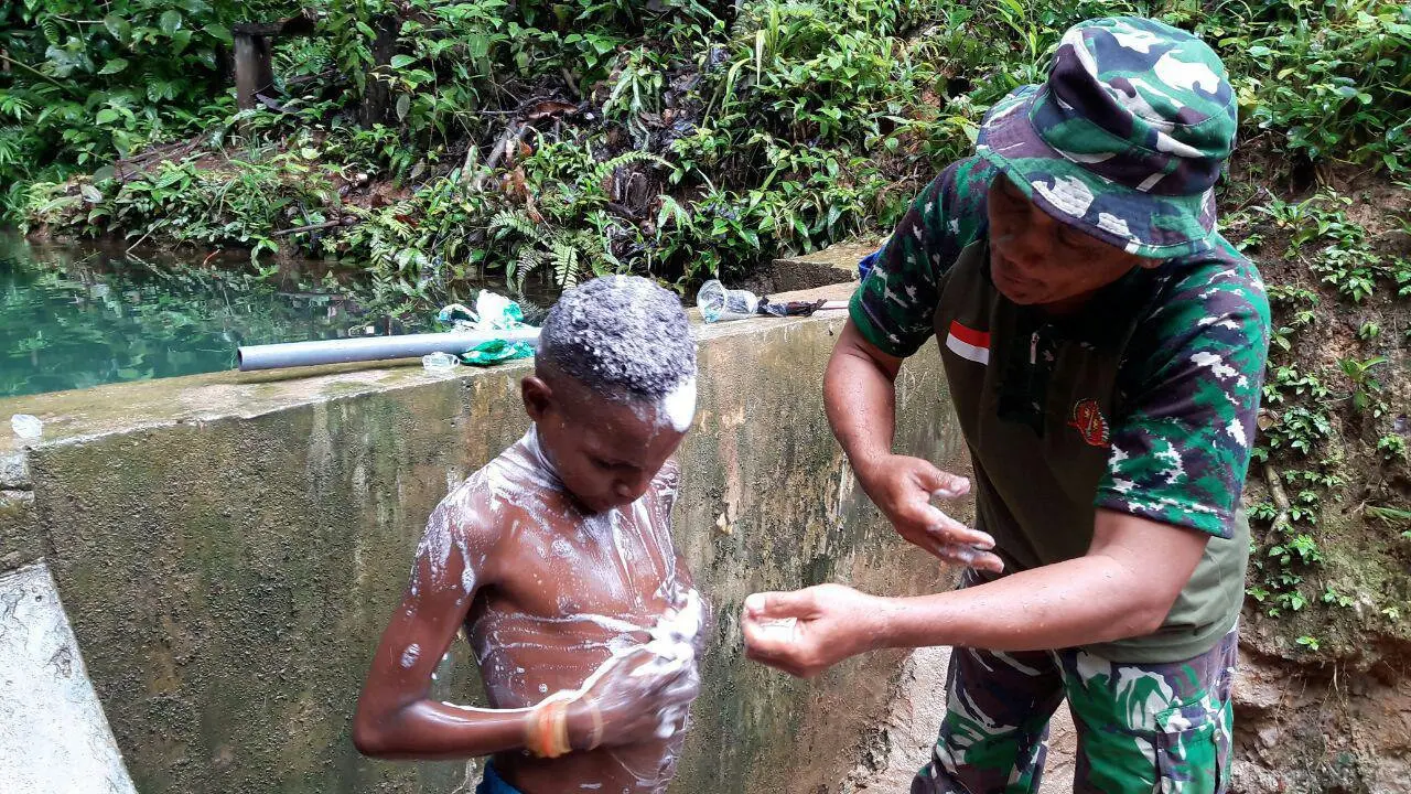 Anggota TNI mengajari mandi anak Boven Digul Papua (Liputan6.com / Katharina Janur)
