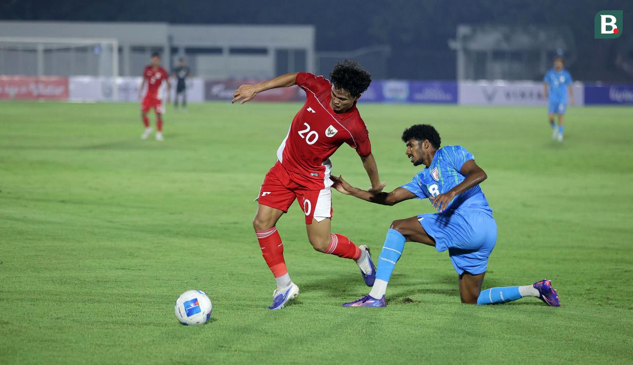 Pemain Timnas Indonesia U-23, Hokky Caraka (kiri) berebut bola dengan pemain India, Mohanan Vibin dalam laga uji coba di Stadion Madya, Senayan, Jakarta, Jumat (10/10/2025). (Bola.com/Muhammad Iqbal Ichsan)