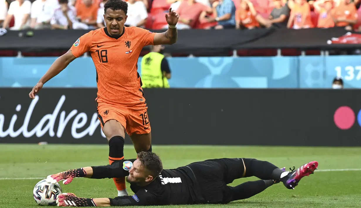 Pemain Timnas Belanda, Donyell Malen (kiri) berebut bola dengan kiper Republik Ceska Tomas Vaclik pada pertandingan babak 16 besar Piala Eropa 2020 antara Belanda melawan Republik Ceska di Puskas Arena, Hongaria, Minggu, (27/6/2021). (Foto: AP/Pool/Attila Kisbenedek)