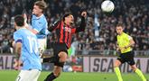 Bek AC Milan asal Swiss, Zachary Athekame (tengah) berebut bola dengan penyerang Lazio asal Denmark, Gustav Isaksen (kedua kiri) selama pertandingan pekan ke-29 Serie A Italia 2025/2026 di Olimpico Stadium, Roma, Minggu 15 Maret 2026 waktu setempat atau Senin (16/3/2026) dini hari WIB. Peluang AC Milan memangkas jarak dengan Inter Milan di klasemen Serie A 2025/2026 kandas. (Alberto PIZZOLI/AFP)