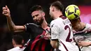 Striker AC Milan, Olivier Giroud (kiri) melepaskan sundulan yang menghasilkan gol ke gawang Salernitana pada laga pekan ke-26 Liga Italia 2022/2023 di San Siro Stadium, Milan, Selasa (14/3/2023) dini hari WIB. (AFP/Marco Bertorello)