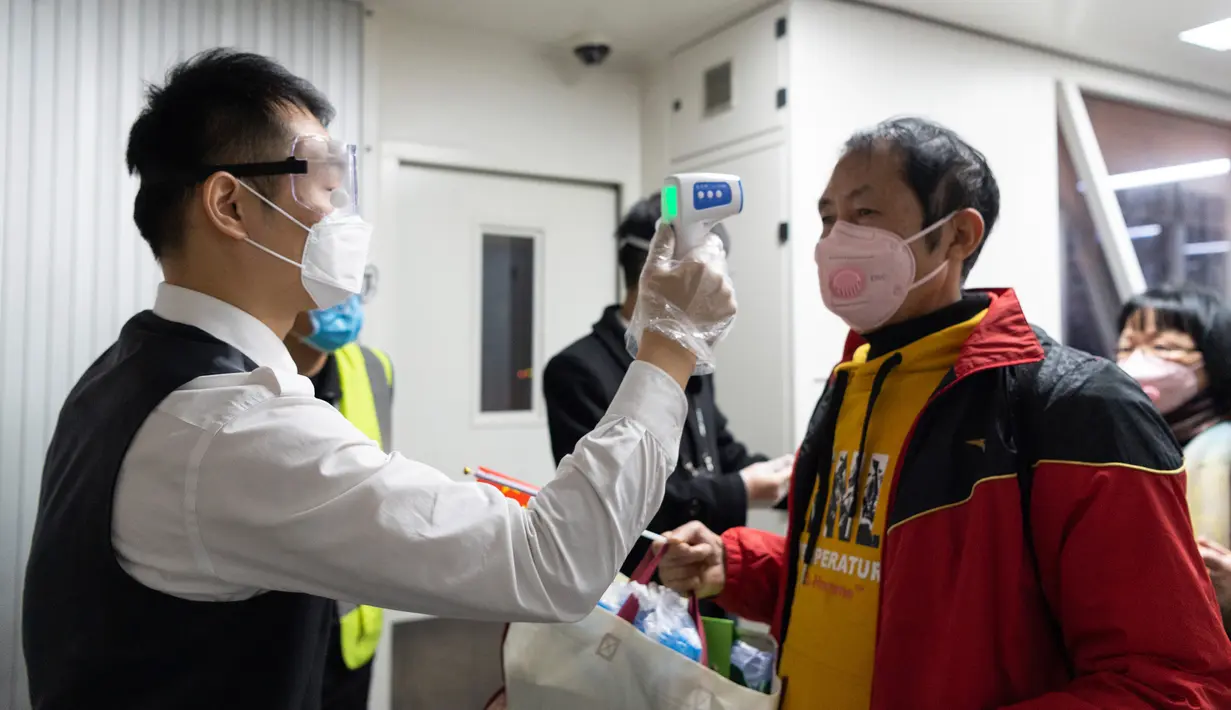 Seorang staf mengukur suhu tubuh penumpang  di Bandara Liuji di Kota Xiangyang, Provinsi Hubei, China (29/3/2020). Layanan penerbangan penumpang domestik kembali beroperasi di Hubei, wilayah yang sempat terdampak COVID-19, kecuali layanan di Bandara Internasional Tianhe Wuhan. (Xinhua/Xie Jianfei)