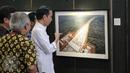 Presiden Joko Widodo melihat karya foto yang dipajang pada pameran foto jurnalistik Setahun Kerja Jokowi-JK di Museum Bank Mandiri, Jakarta, Jumat (18/12). Foto tersebut merupakan karya para anggota Pewarta Foto Indonesia (Liputan6.com/Faizal Fanani)