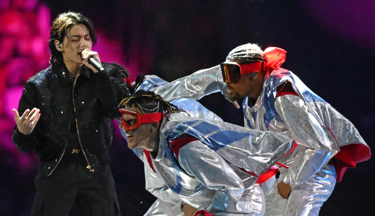 <p>Aksi Jungkook saat tampil di atas panggung dalam upacara pembukaan Piala Dunia Qatar 2022, di Stadion Al Bayt di Al Khor, Qatar, Minggu (20/11/2022). Jungkook tampil dalam busana serba hitam saat menghibur penonton Piala Dunia 2022 Qatar. (AFP/Raul Arboleda)</p>