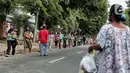 Warga menerapkan jaga jarak aman saat antre untuk mendapatkan takjil di Jalan Cempaka Putih Raya, Jakarta, Senin (11/5/2020). Setiap hari selama Ramadan, masyarakat sekitar membagikan 350 takjil kepada warga kurang mampu dan terdampak virus corona COVID-19. (Liputan6.com/Johan Tallo)