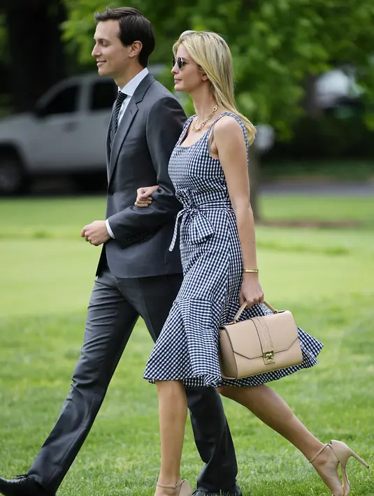 Ivanka Trump bersama sang suami berjalan menuju Marine One di Gedung Putih di Washington, DC (4/5). Mengenakan Dress kotak-kotak dengan kaca mata hitam Ivanka tampil mempesona. (AFP Photo/Mandel Ngan)