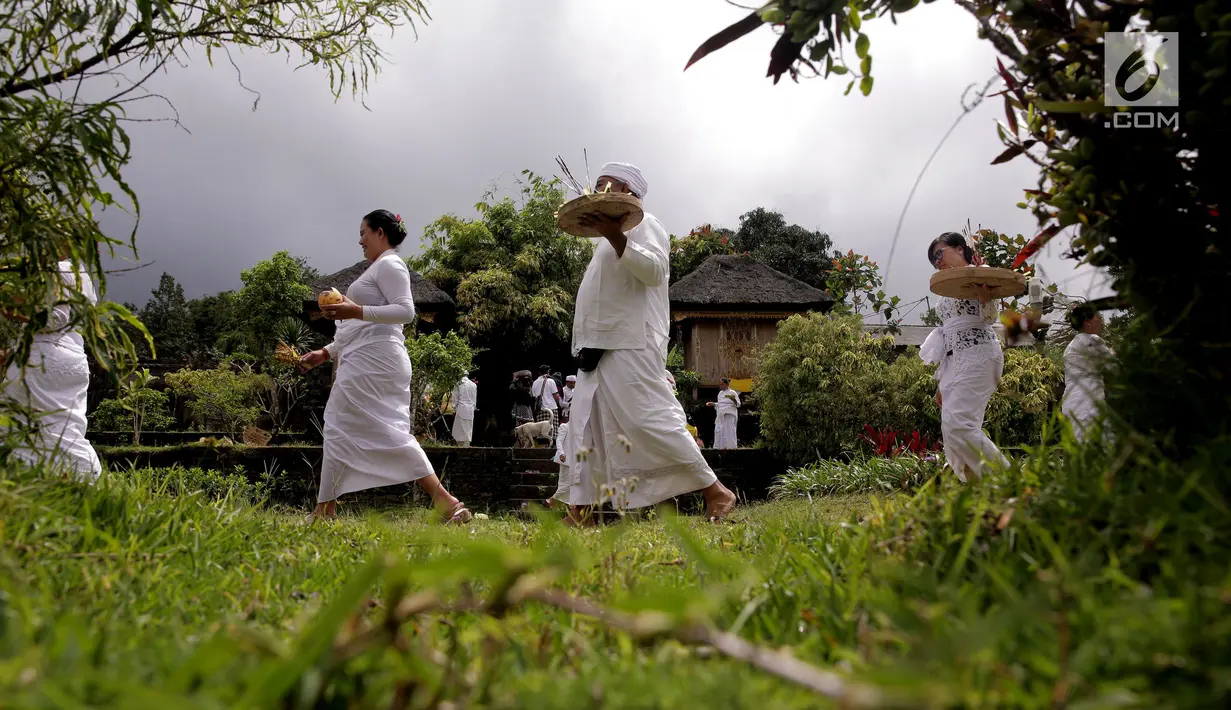 Umat Hindu membawa sesajen dalam prosesi ritual tahunan Purnama Kapat di Pura Besakih, Karangasem, Bali, Kamis (5/10). Ritual tersebut juga dijadikan momentum untuk doa bersama agar bencana gunung meletus tidak terjadi. (Liputan6.com/Gempur M Surya)