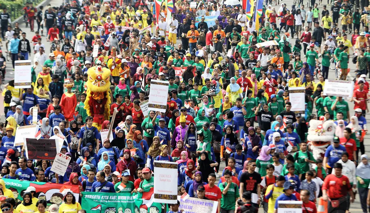 Ribuan orang berlongmarch dari Bundaran HI menuju kawasan Patung Kuda, Jakarta, Minggu (16/11/2014). (Liputan6.com/Faizal Fanani)