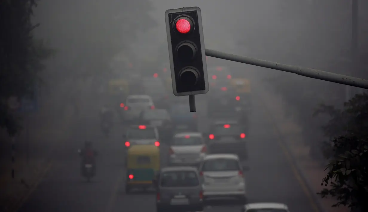 Suasana lalu lintas pada pagi hari saat kabut tebal akibat polusi menyelimuti kota Delhi, India (1/12). Akibat polusi yang amat tebal, banyak warga yang mengeluhkan derita sesak nafas, sakit mata, dan batuk-batuk. (REUTERS/Cathal McNaughton)