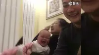 Bayi yang tertawa melihat ayahnya menghitung uang. (Weibo)