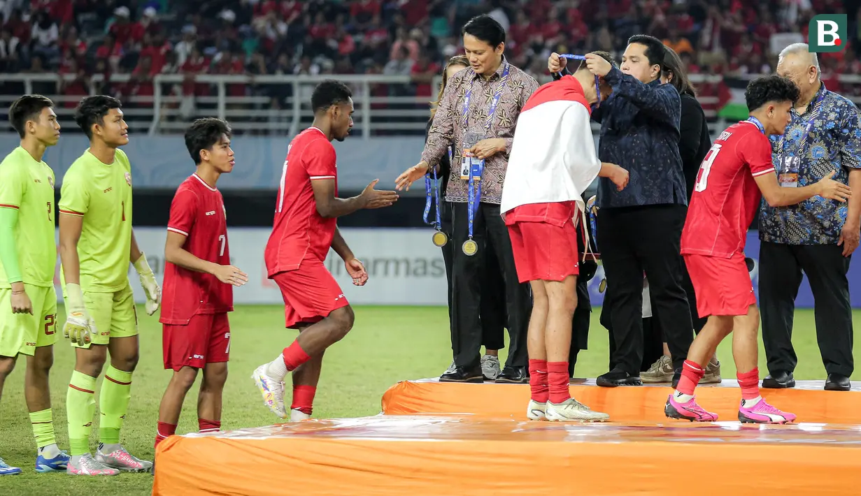<p>Skuad Timnas Indonesia U-19 yang menjadi juara Piala AFF U-19 2024 setelah mengalahkan Thailand menerima pengalungan medali yang disematkan oleh Ketua Umum PSSI, Erick Thohir usai laga final di Stadion Gelora Bung Tomo, Surabaya, Senin (29/7/2024). (Bola.com/Bagaskara Lazuardi)</p>