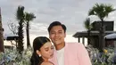 Adzwa Aurel tampil dengan long dress pink satin backless dipadukang anting-anting model bunga. [@iniadzwaaurel]