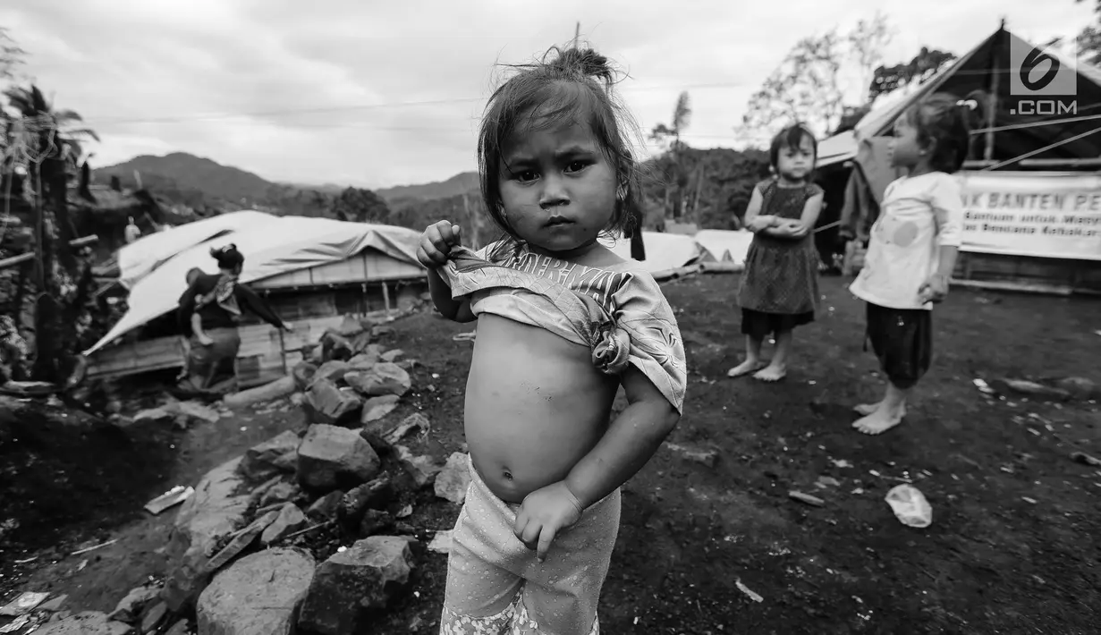 Seorang anak perempuan Suku Baduy Luar dengan menarik bajunya pose di lokasi bekas kebakaran Kampung Cisaban II, Desa Kanekes, Banten, Kamis (01/6). Kebakaran pada pekan lalu yang menghanguskan 83 rumah Suku Baduy Luar. (Liputan6.com/Fery Pradolo)