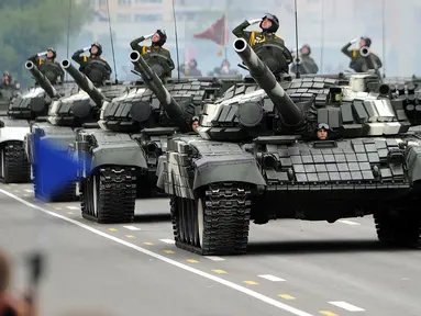 Tentara Belarus memberi hormat saat mengendarai tank dalam sebuah parade militer menandai Hari Kemerdekaan di Minsk (3/7). (AFP Photo/Sergie Gapon)