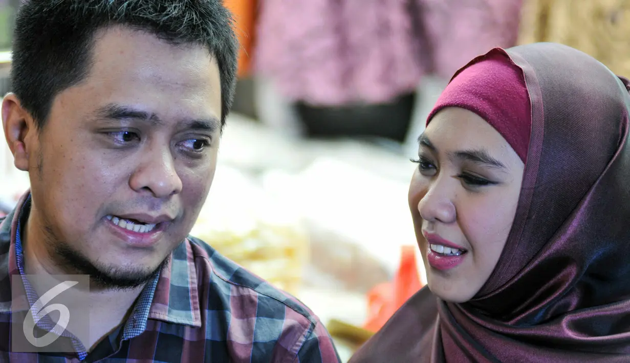 Oki Setiana Dewi bersama suami menjawab pertanyaan awak media saat peresmian toko busana muslimnya yang ke-4 di Tanah Abang, Jakarta, Rabu (2/12). (Liputan6.com/Yoppy Renato)
