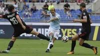 Aksi pemain Lazio, Luis Alberto (tengah) melakukan tembakan melewati dua pemain AC Milan pada lanjutan Serie A di Rome Olympic stadium, (10/9/2017). Lazio menang 4-1. (AP/Alessandra Tarantino)