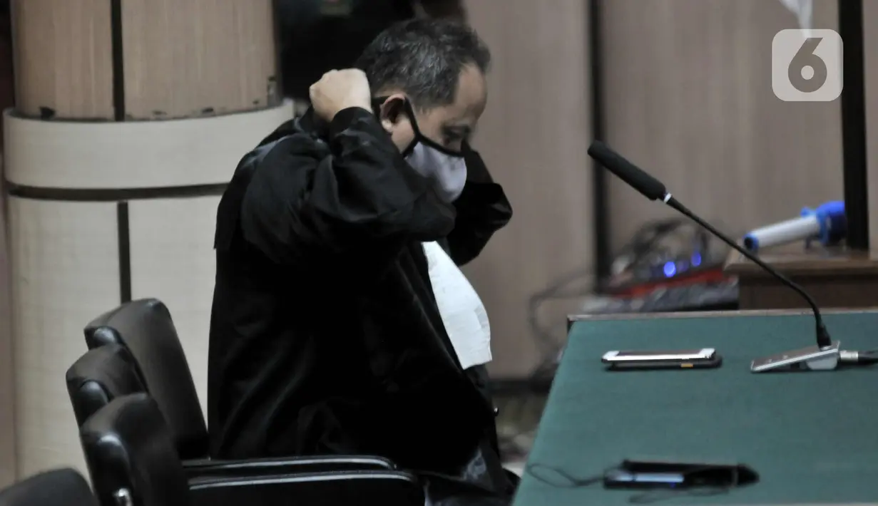 Jaksa mengenakan masker sebelum mengikuti persidangan di Pengadilan Negeri Jakarta Utara, Kamis (19/3/2020). Pihak PN Jakarta Utara menerapkan social distancing bagi tamu persidangan mengikuti kebijakan Pemprov DKI guna mencegah penyebaran virus Conora Covid-19. (merdeka.com/Iqbal Nugroho)