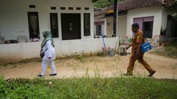 Tidak sendiri, Siti Nurjanah bersama rekan-rekannya rela menyusuri permukiman warga untuk memberikan vaksinasi campak kepada anak-anak yang telah terdaftar. (AP Photo/Dita Alangkara)