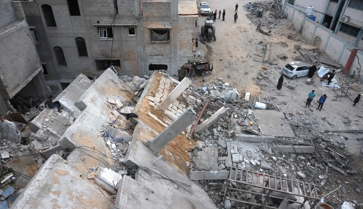 Serangan Israel ini diluncurkan meski perjanjian gencatan senjata antara kedua pihak berseteru masih berlaku. Tampak dalam foto, warga Palestina yang mengungsi memeriksa kerusakan setelah pesawat Israel menargetkan sebuah rumah berlantai lima tadi malam, di Khan Yunis, Jalur Gaza selatan, pada Kamis 6 Februari 2026. (Bashar Taleb/AFP)