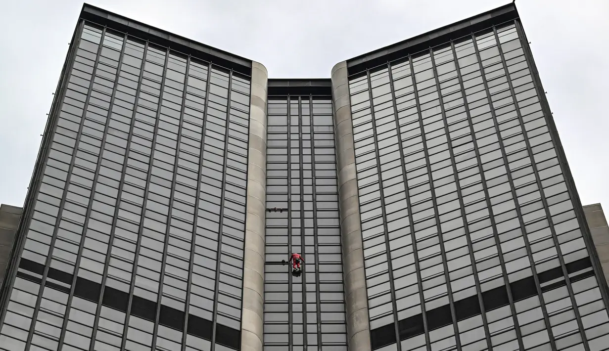 Alain Robert, pendaki bangunan pencakar langit asal Prancis memanjat Menara Montparnasse di Paris, Prancis, Rabu (12/10/2022). Alain Robert yang dikenal sebagai Spiderman Prancis itu kembali beraksi dengan memanjat Menara Montparnasse yang memiliki ketinggian 210 meter. (Bertrand GUAY/AFP)