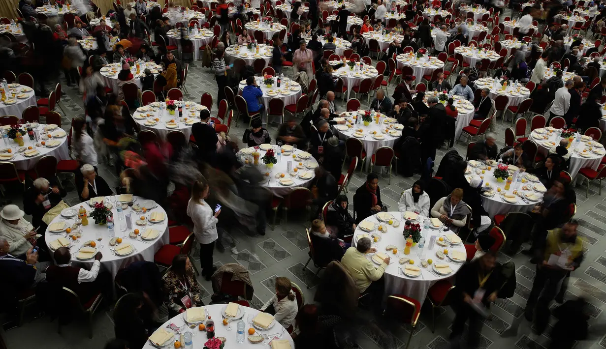 Orang-orang menunggu kedatangan Paus Fransiskus untuk makan siang di Aula Paul VI, Vatikan, Minggu (17/11/2019). Paus Fransiskus mengundang sekitar 1.500 orang miskin, tunawisma, imigran dan pengangguran untuk makan siang dalam memperingati Hari Orang Miskin Sedunia. (AP/Alessandra Tarantino)