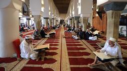 Umat Muslim berkumpul untuk membaca Al-qur'an pada hari pertama bulan suci Ramadhan di Masjid Al-Kabir di kota tua Sanaa, ibu kota Yaman, 2 April 2022. Pada bulan Ramadhan umat muslim memanfaatkan waktu untuk memperbanyak ibadah dengan membaca Al Quran. (MOHAMMED HUWAIS/AFP)