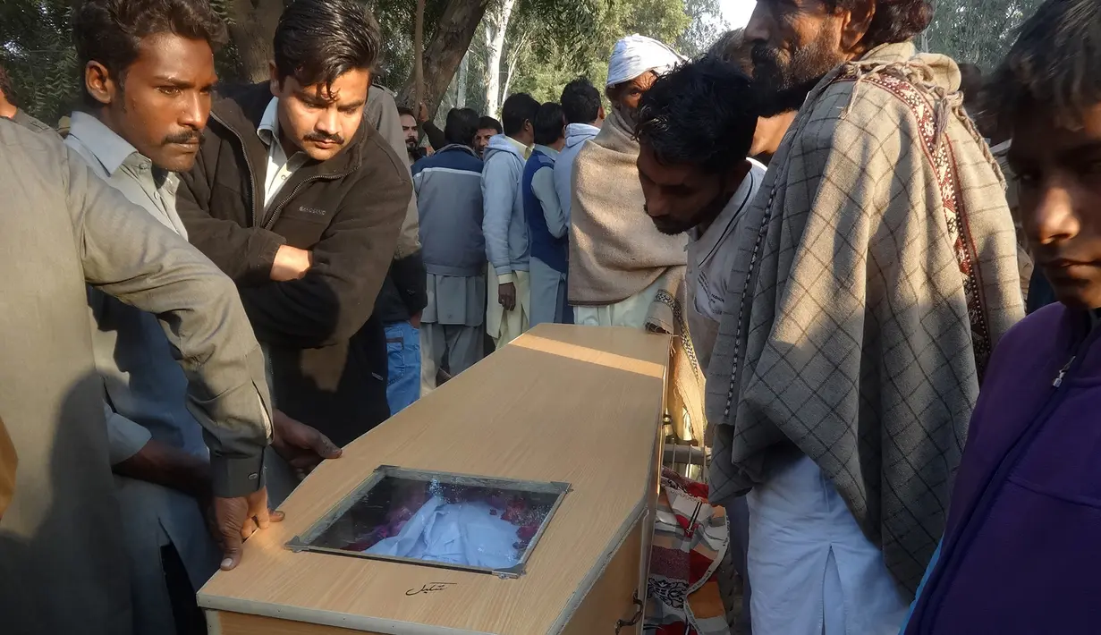 Peti jenazah korban tewas akibat minuman keras oploson di Toba Tek Singh, sekitar 338 km dari Islamabad, Selasa (27/12). Sebanyak 24 orang di kalangan kelompok kecil Kristen di Pakistan tewas setelah mengonsumsi miras oplosan saat perayaan Natal (STR/AFP)