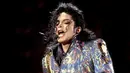 Di sini Michael Jackson terlihat mengenakan thong emas di luar celana hitam ketatnya. Ia memadukannya dengan jaket hologram bersiluet lebar dan gaya Rambo yang berkilauan. Foto: Mick Hutson/Redfrens/Glamour.