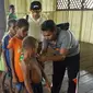 Satgas Kesehatan TNI memberi vaksin campak terhadap anak-anak di Kabupaten Asmat, Papua, Jumat (19/1). Tim Gabungan Satgas Kesehatan TNI KLB menyalurkan bantuan berupa vaksin ke kampung-kampung terpencil di Kabupaten Asmat. (LIputan6.com/Pool/Puspen TNI)